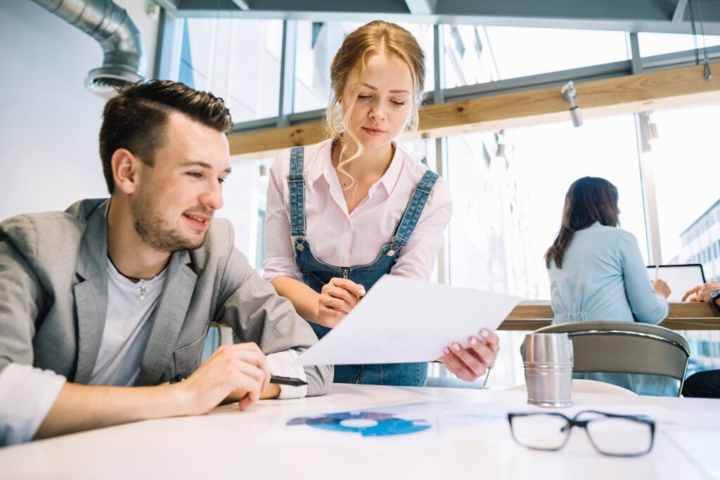 Doradca biznesowy omawia z klientką dokumenty dotyczące zakładania firmy