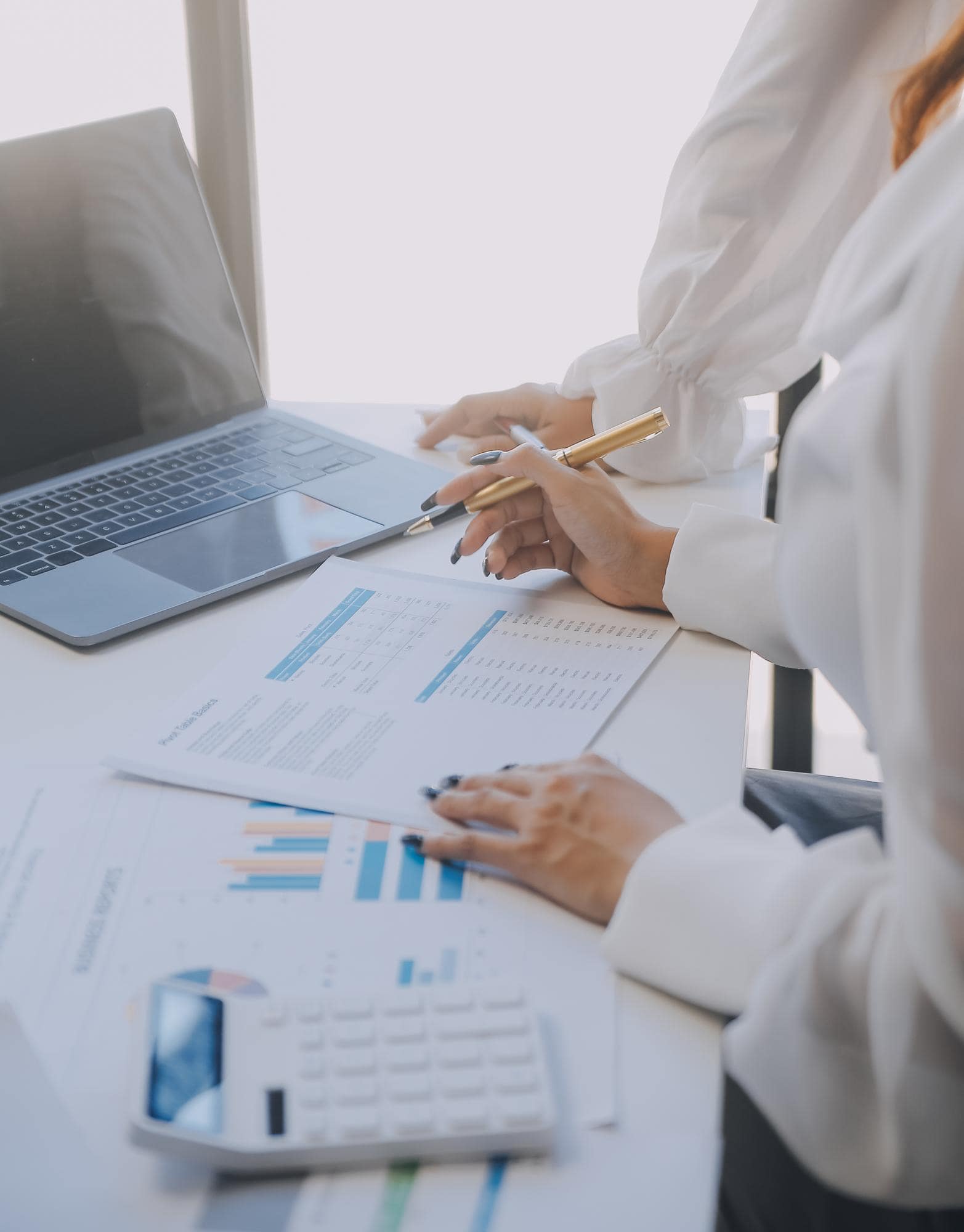 Księgowa Simpletax w Łodzi opracowuje sprawozdanie finansowe spółki, analizując raporty i dane w Excelu przy laptopie